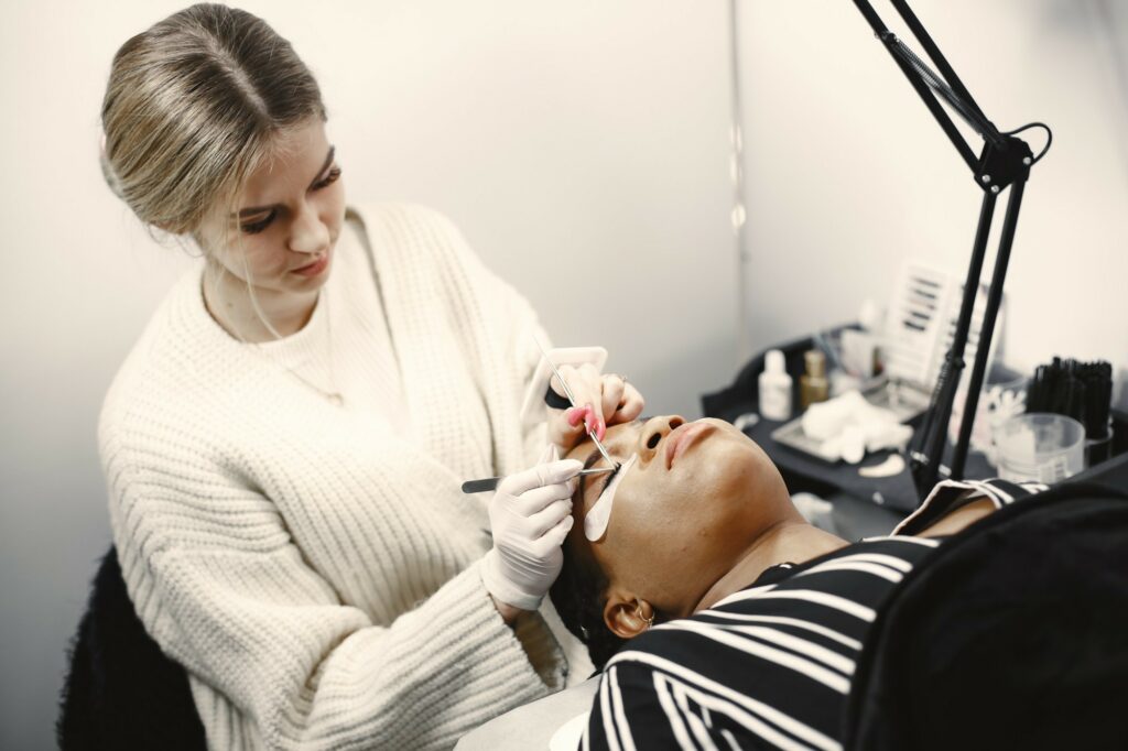 a lash technician showing a trainee how to become a lash technician