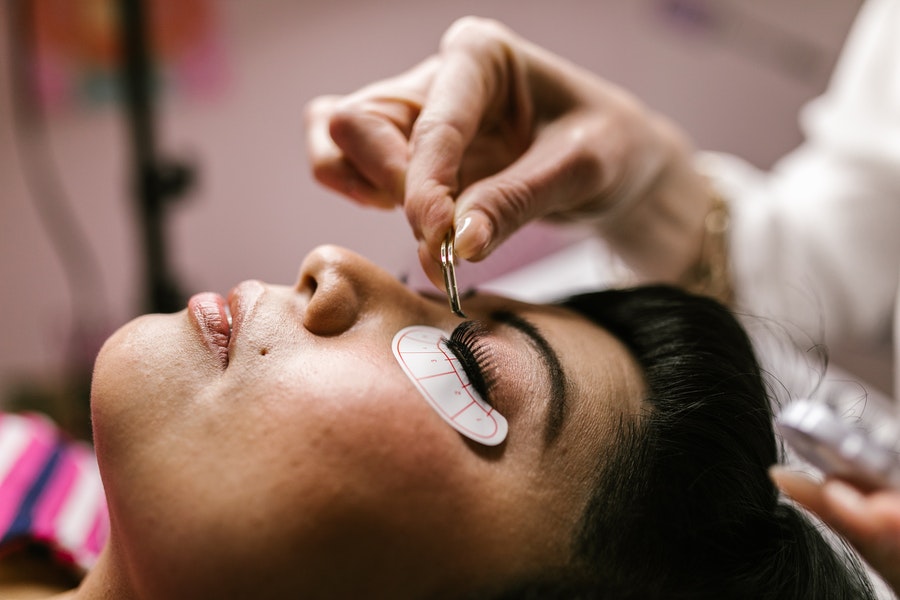 a lash technician mapping out eyelash extensions